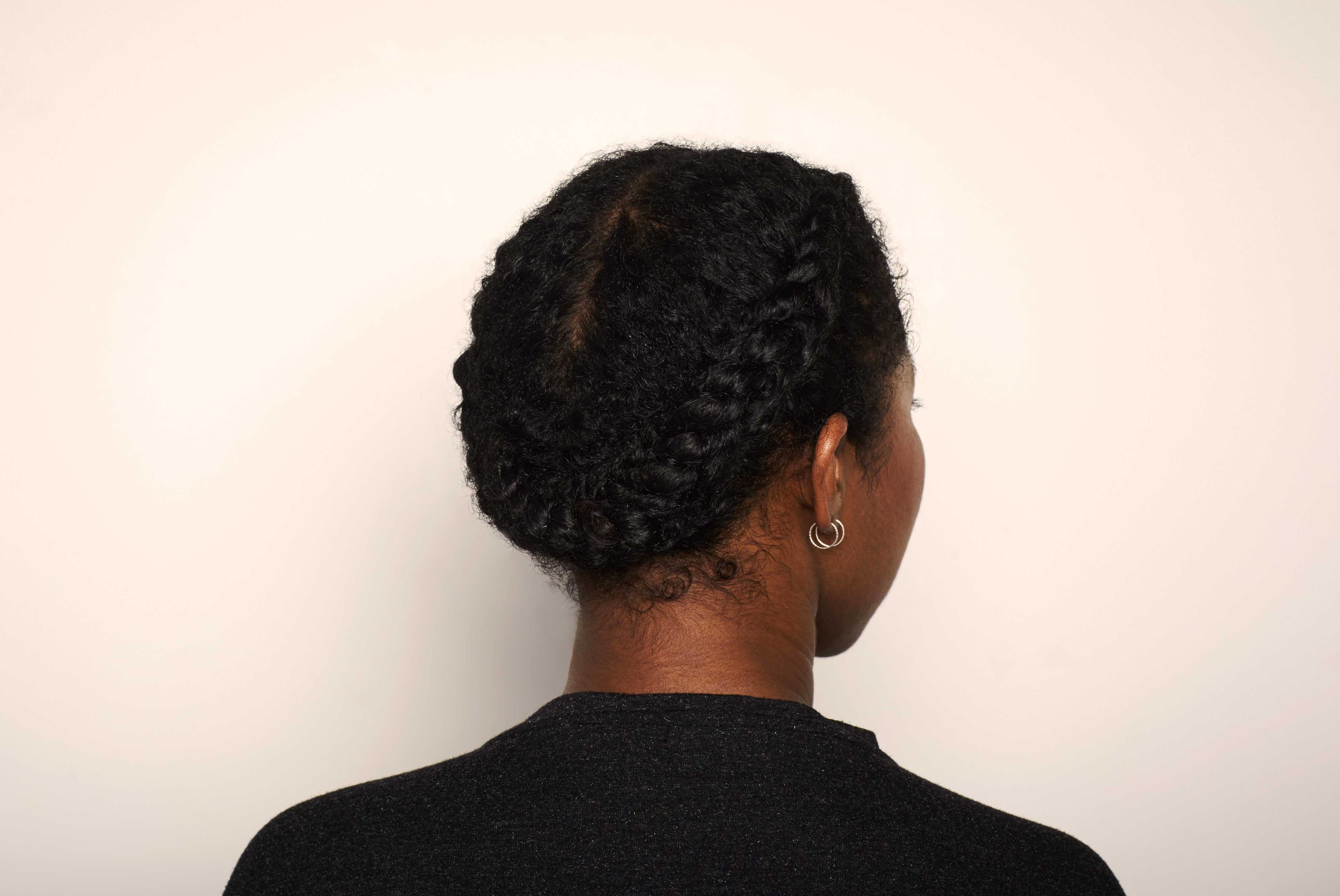 curly updos: model jeanette with a brown afro and a curly hair halo braid/ reverse milkmaid braid