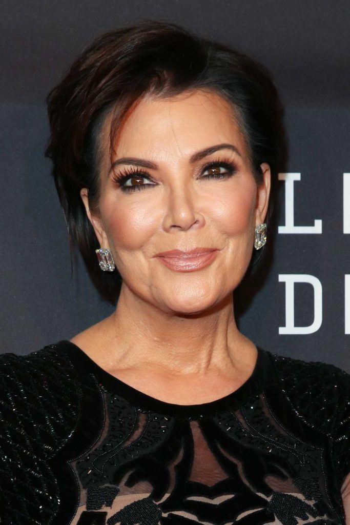 Kris Jenner on the red carpet with her dark brown hair styled into a pixie crop