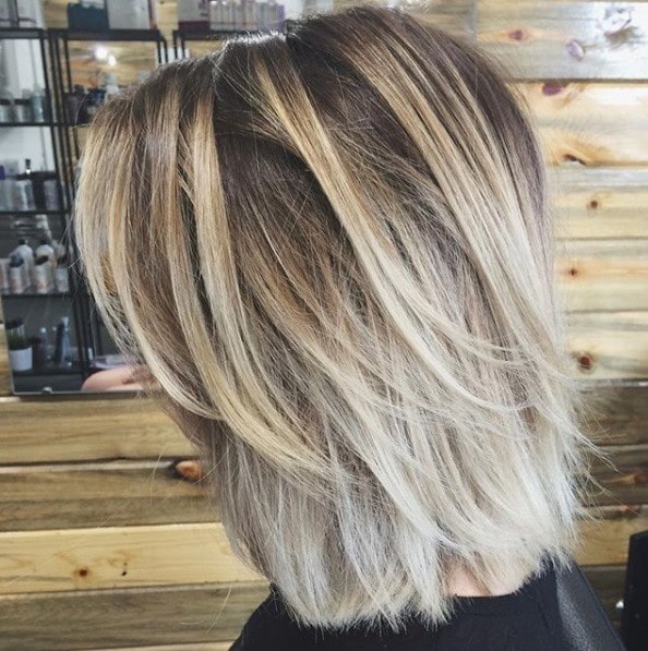 Layered bob: Sidevisning av en kvinne med en askeblond bob med lange lag