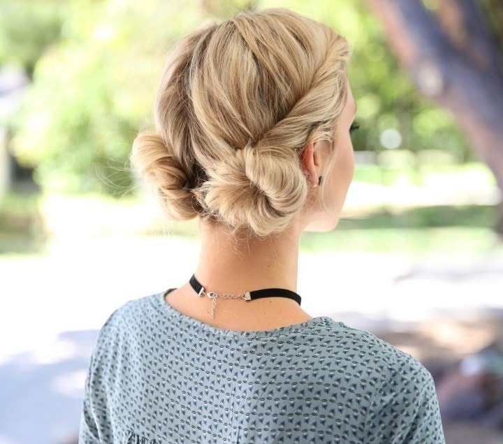 backshot van vrouw met blond haar dat in twee lage knotjes is gedraaid