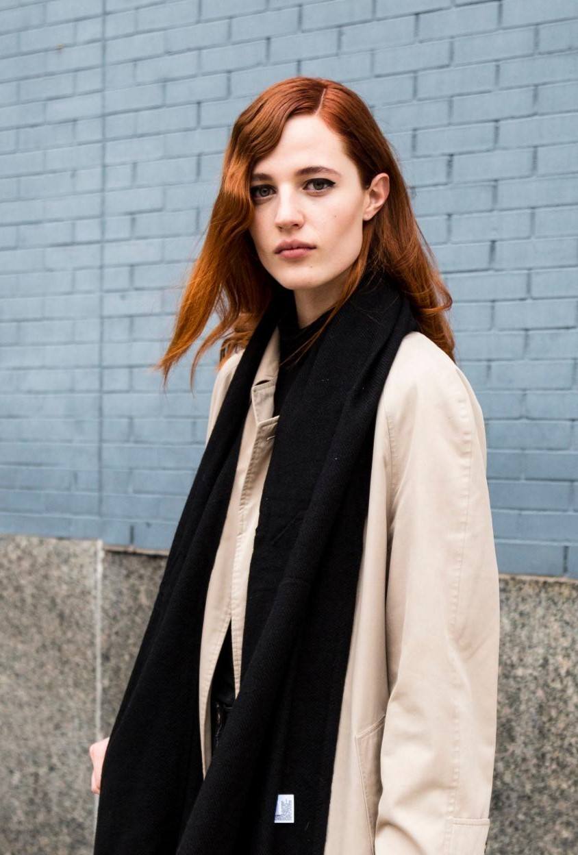 2019 hair colour trends: Street style shot of a woman with copper shoulder length hair with retro curls, wearing a black scarf and beige coat