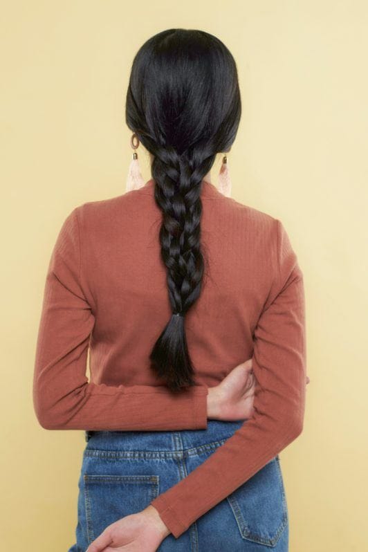 Nine strand braid: Back shot of Asian woman wearing long-sleeved shirt with long black hair in nine strand braid