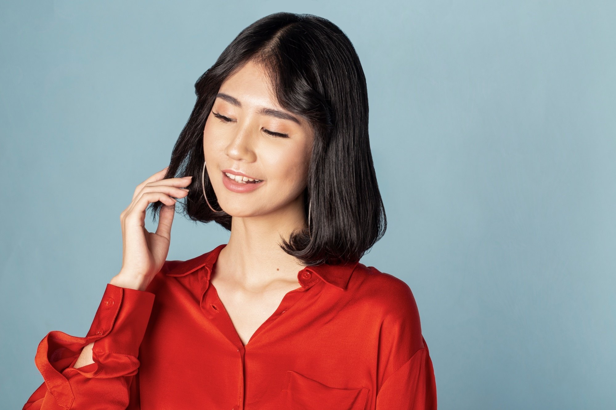 Asian woman with Korean short hair wearing a red top